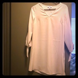 Light pink 3/4 sleeve dress with bow detail.